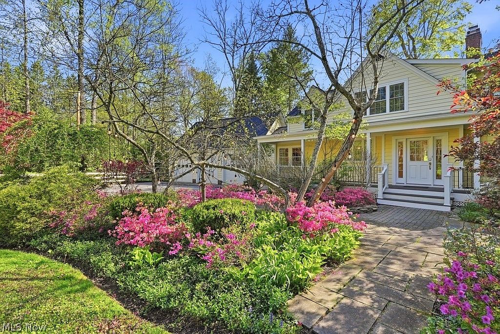 Spring azaleas in full pink and magenta bloom flanking the covered front porch and walkway